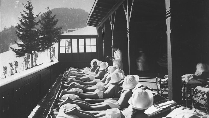 Auf dem Schwarzweiß-Foto sieht man mehrere Mädchen bäuchlings auf Liegestühlen liegen. | Bildquelle: akg Auf dem Schwarzweiß-Foto sieht man mehrere Mädchen bäuchlings auf Liegestühlen liegen.