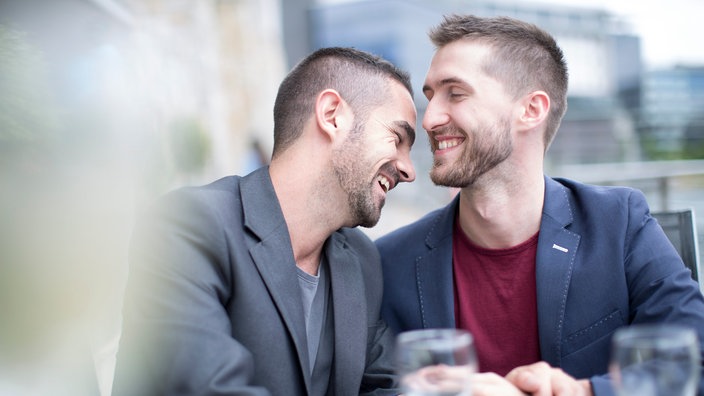 Ein junges Paar in einem Café: die beiden Männer lachen zusammen. | Bildquelle: dpa Picture-Alliance / zerocreat Ein junges Paar in einem Café: die beiden Männer lachen zusammen.