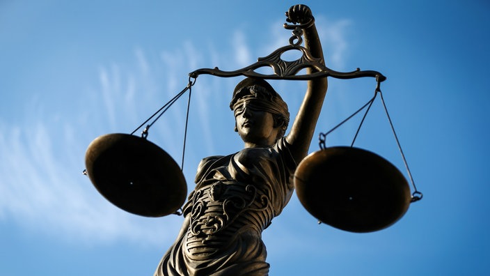 Figur der Justitia mit Waage und Augenbinde vor blauem Himmel | Bildquelle: dpa/David Ebener Figur der Justitia mit Waage und Augenbinde vor blauem Himmel