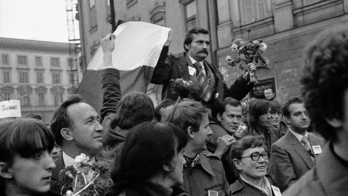Schwarzweiß-Foto: Lech Wałęsa wird von einer jubelnden Menge getragen | Bildquelle: picture-alliance/dpa Schwarzweiß-Foto: Lech Wałęsa wird von einer jubelnden Menge getragen