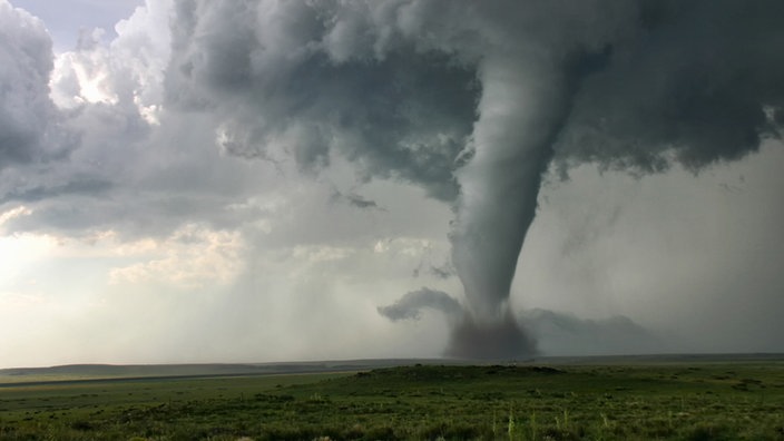 Flache Landschaft mit dunkel bewölktem Himmel aus dem ein Tornado zum Boden reicht. | Bildquelle: Mauritius/Cultura Flache Landschaft mit dunkel bewölktem Himmel aus dem ein Tornado zum Boden reicht.